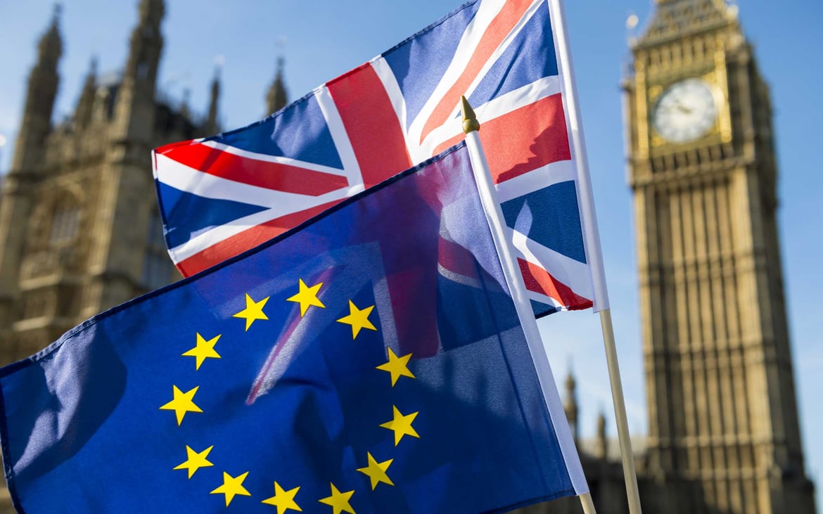 The European and English flags flying in front of Big Ben in London. 