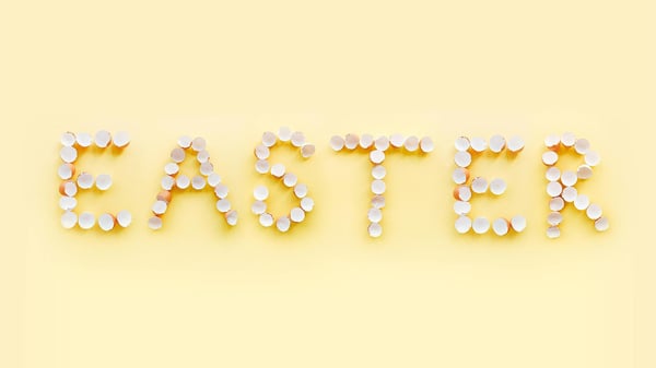 Egg shells spelling out the word Easter on a pale yellow background.