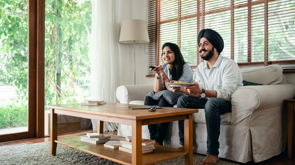 An Indian couple sit in their newly purchased dream home. 
