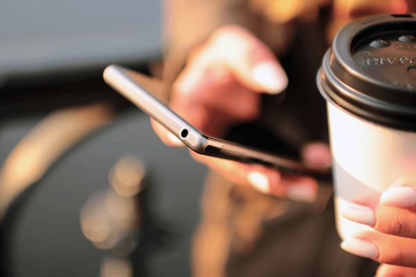man-holding-phone-and-coffee