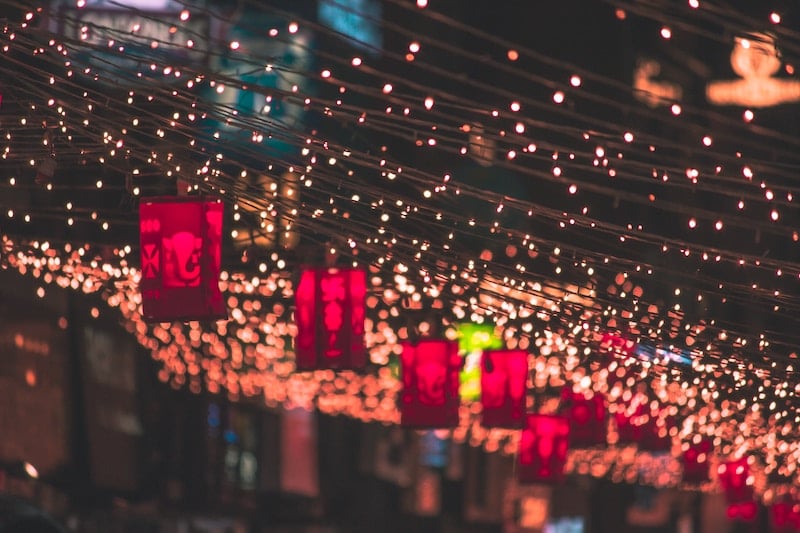 Illuminated lantern lights strung up in a street.