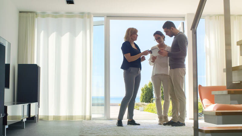 couple with realtor in sunny apartment living room