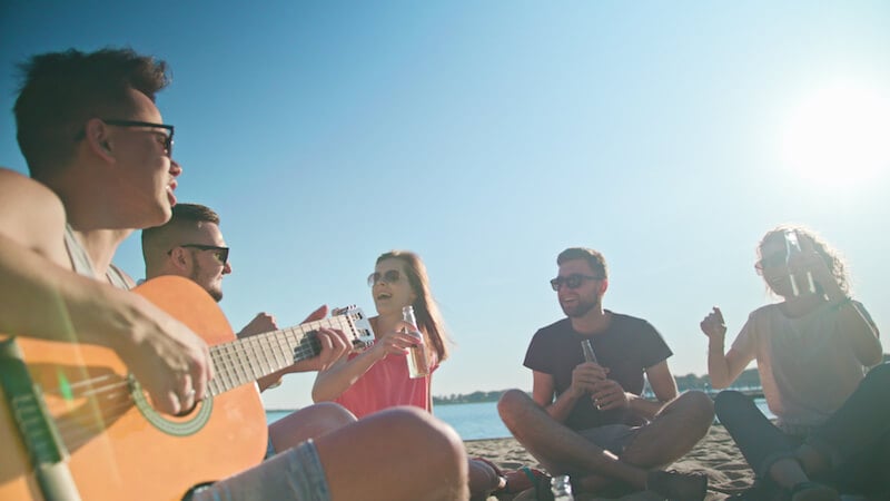 laughing friends sitting in circle in the sun