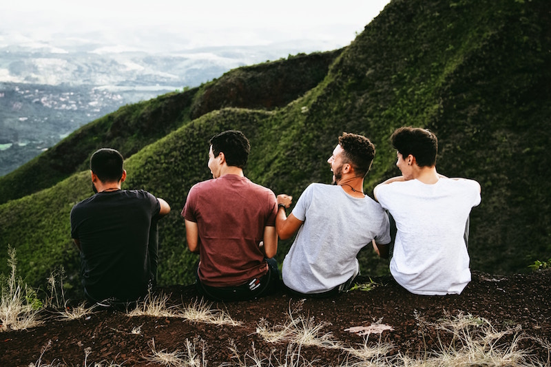 men laughing on hilltop