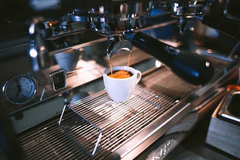 white cup of espresso in coffee machine