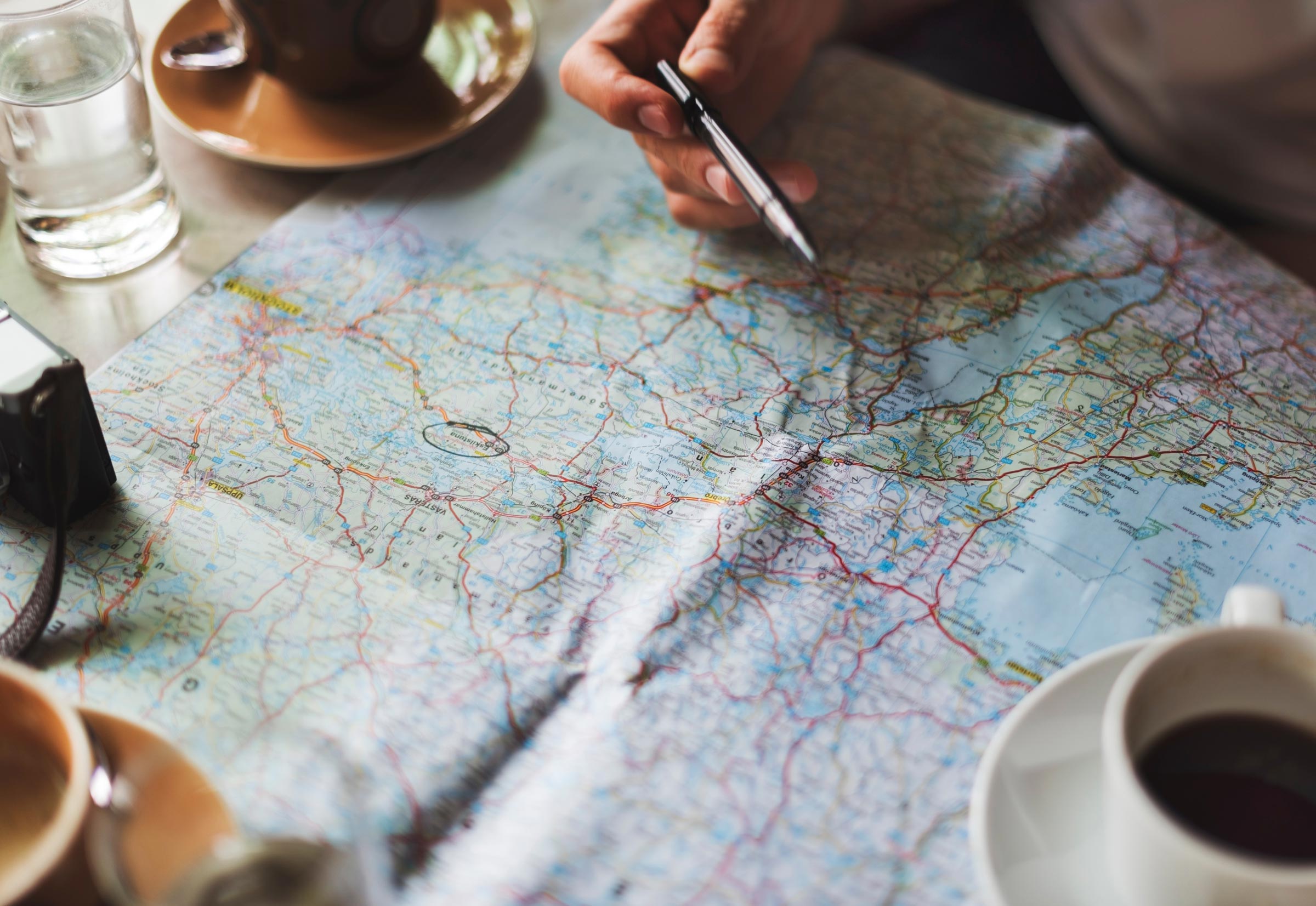 map on table with coffee cups