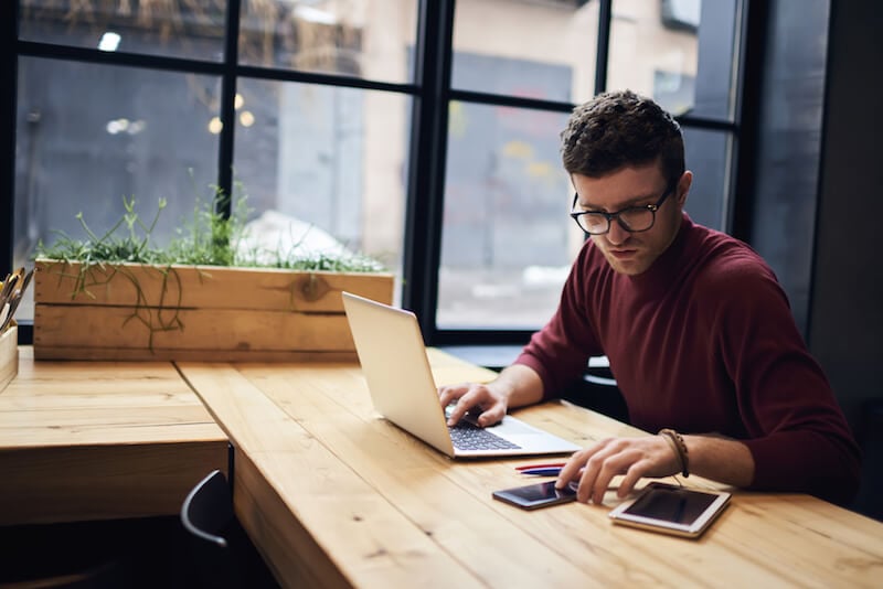 young man working at laptop in cafe