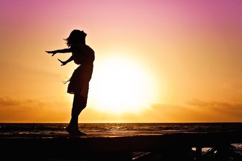 silhouette of woman on beach at sunset