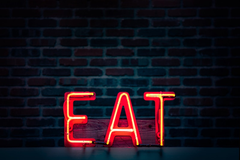 red led sign on wall of the word eat