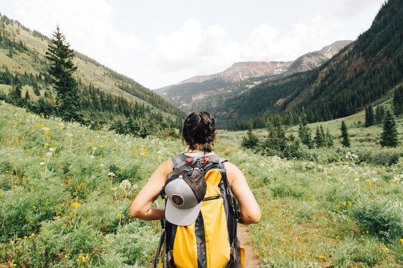 women with backpack hking in hills